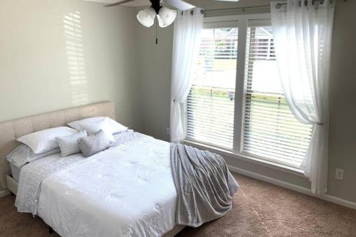 a bedroom with a bed and a large window at Peaceful 3BR/2BA Hidden Lake Home Near ACOM w/WiFi in Dothan