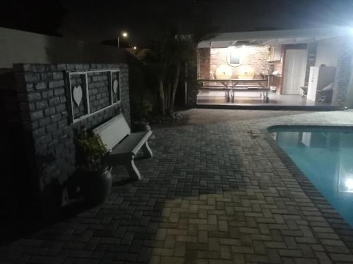 a bench next to a swimming pool at night at 420 on Cape in Port Elizabeth