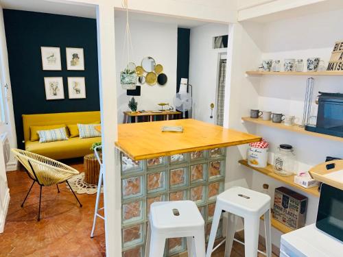 - une cuisine avec une table et des tabourets dans une pièce dans l'établissement Un petit cocon en plein centre de Marseille, à Marseille