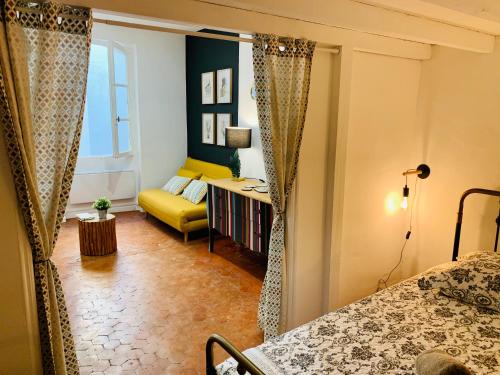 Cette chambre comprend un lit et un canapé jaune. dans l'établissement Un petit cocon en plein centre de Marseille, à Marseille