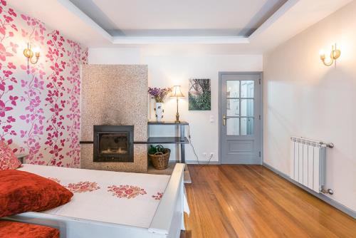 a living room with a bed and a fireplace at Praça Guest House in Arouca