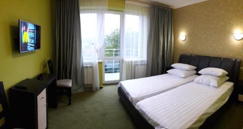 una camera d'albergo con letto e finestra di Guest House at Lesya Ukrainka a Truskavec'