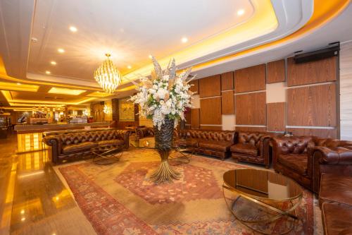 a lobby with leather furniture and a vase of flowers at Ramada By Wyndham Istanbul Pera Taksim in Istanbul