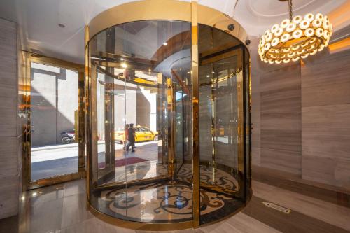 a large glass elevator in a building with a person walking at Ramada By Wyndham Istanbul Pera Taksim in Istanbul
