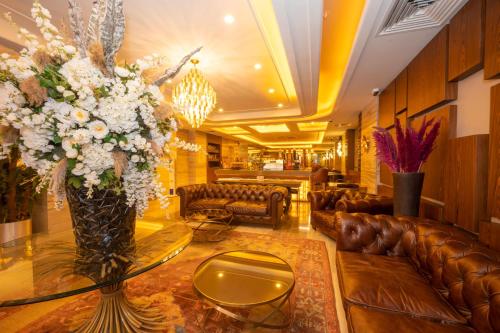 a lobby with couches and a table with a vase of flowers at Ramada By Wyndham Istanbul Pera Taksim in Istanbul