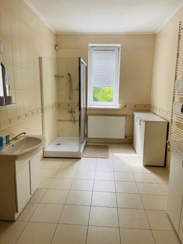 a white bathroom with a shower and a sink at Guest House at Lesya Ukrainka in Truskavets