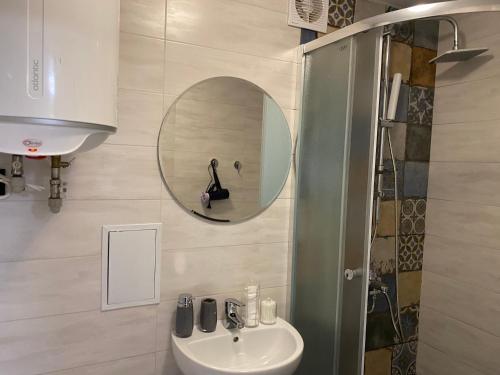 W łazience znajduje się umywalka i lustro. w obiekcie Апартаменты в самом центре города w mieście Czernihów