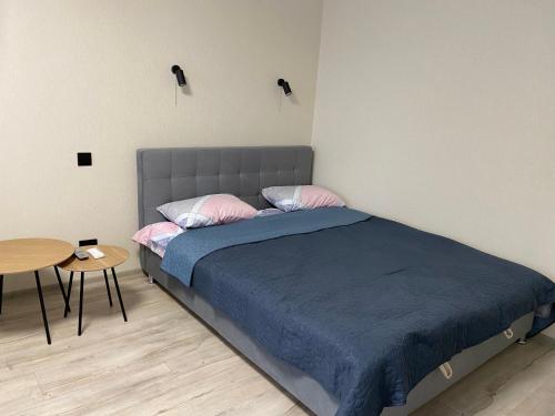 sypialnia z łóżkiem i małym stołem w obiekcie Апартаменты в самом центре города w mieście Czernihów
