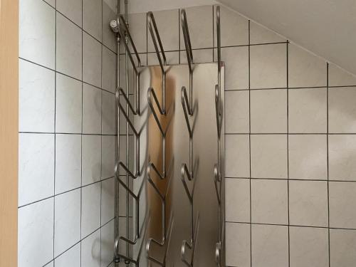 a shower in a bathroom with white tiles at Haus Wierer in Mayrhofen