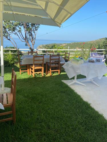 a table and chairs with a view of the ocean at Persephone in Himare