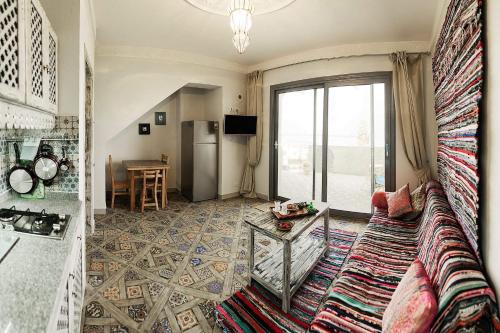 a living room with a couch and a refrigerator at Ganesha.Beach apartment in Dahab