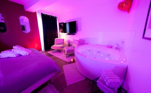 ein lila Zimmer mit einem Bett und einer Badewanne in der Unterkunft LoveSparadise -Suite Le Secret in Saints