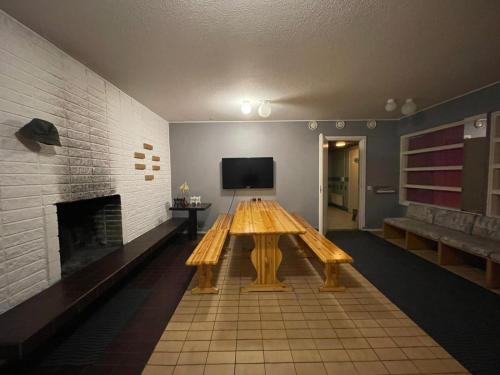 ein Holztisch in einem Raum mit Kamin in der Unterkunft hotelli ravintola kurenkoski in Pudasjärvi