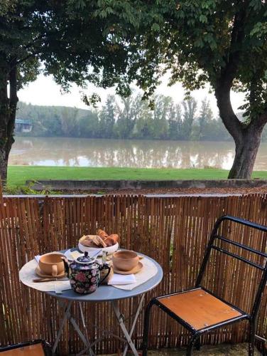 ein Tisch mit einem Teller Essen darauf in der Unterkunft Chambre de la galerie du port "Douce France" in Auvillar
