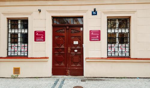 a building with a brown door and two windows at Safestay Prague Charles Bridge in Prague