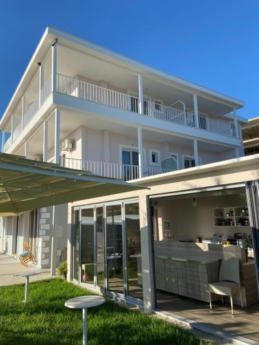 a large white house with a balcony and patio at Persephone in Himare