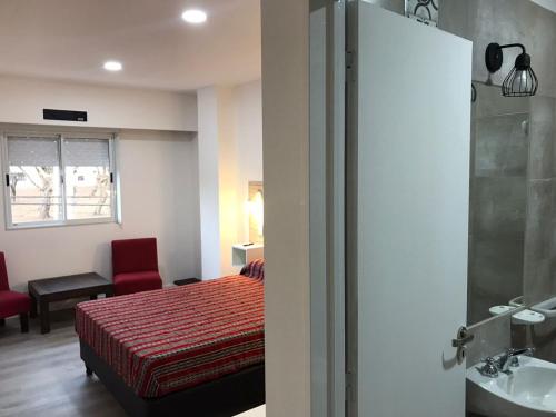 1 dormitorio con 1 cama y baño con lavamanos en Guest House Salta en Salta