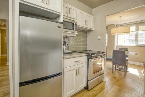 a kitchen with a stainless steel refrigerator and a table at Town Inn Suites Hotel in Toronto