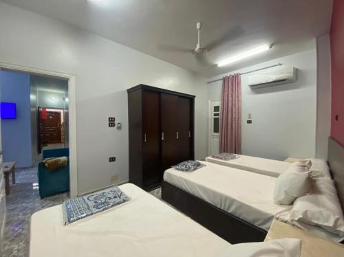 um quarto de hotel com duas camas e um espelho em ALRahman Building em Aswan