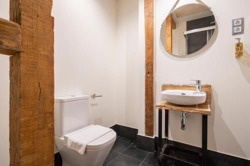 a bathroom with a white toilet and a sink at Dobo Azacanes Hostal in Toledo