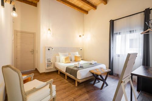 a bedroom with a bed and a table and a chair at Dobo Azacanes Hostal in Toledo