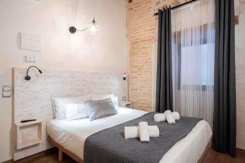 a bedroom with a bed with two towels on it at Dobo Azacanes Hostal in Toledo