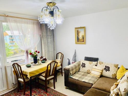 uma sala de estar com uma mesa e um sofá em apartament Durau em Durau