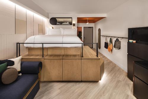 a bedroom with a bed and a couch at Catbird Hotel in Denver