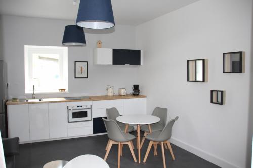 une cuisine avec une table, des chaises et un évier dans l'établissement Au fil de l'eau La Cale 30m², à Lannion
