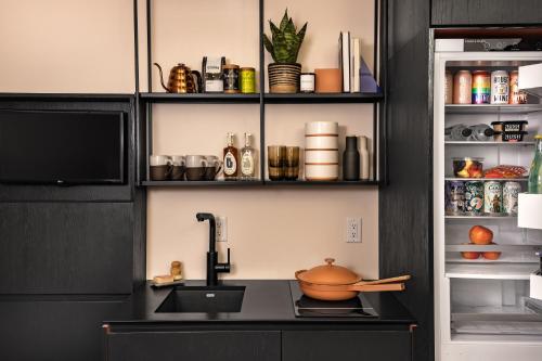 a kitchen with a sink with a pot on a counter at Catbird Hotel in Denver