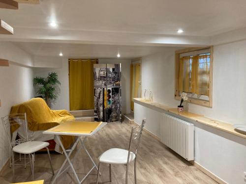 une cuisine avec une table et des chaises dans une pièce dans l'établissement Cottage de Noëlle, à Limoges