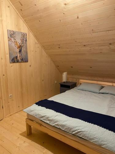 sypialnia z łóżkiem w drewnianym domku w obiekcie Lasoterapia (Foresttherapy) w mieście Sopieszyno