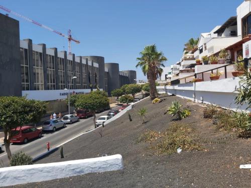 een straat met auto's aan de zijkant van een gebouw bij Casa Lucia in Puerto del Carmen