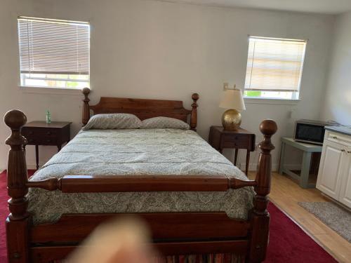 a bedroom with a wooden bed and two windows at Va beach zen studio C in Virginia Beach