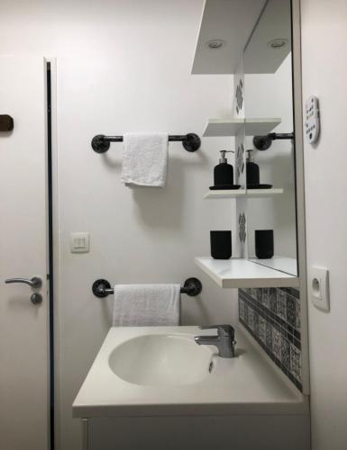 une salle de bain blanche avec un lavabo et un miroir dans l'établissement LISACA, à Camaret-sur-Mer