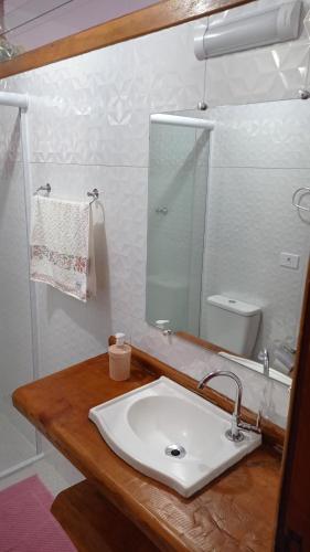 a bathroom with a sink and a mirror at Cantinho Feliz a 900m do Capivari in Campos do Jordão