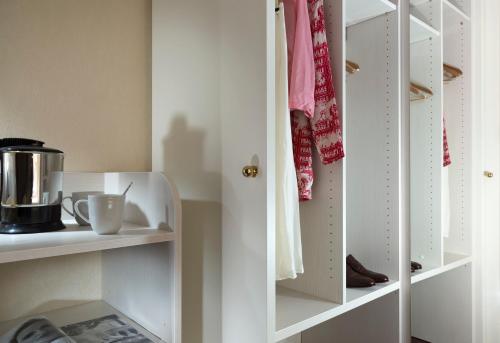 a kitchen with white shelves and a cupboard at Doria Park Hotel in Lerici