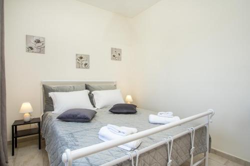 a bedroom with a bed with two pillows on it at Economisa Apartments in Ialyssos