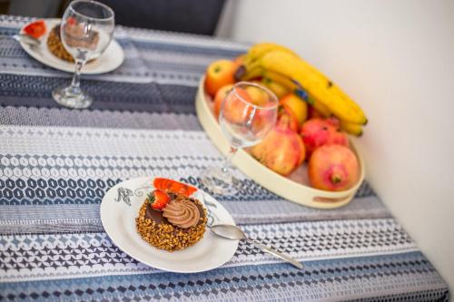 a table with a plate of food and a bowl of fruit at Economisa Apartments in Ialyssos