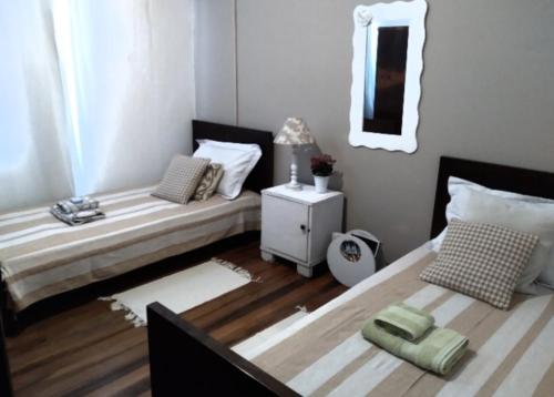 a bedroom with two beds and a mirror at Quarto em casa compartilhada in Florianópolis