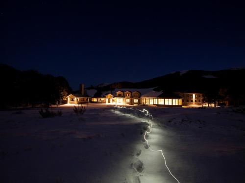 a house lit up at night in the snow at Valle Corralco Hotel & Spa in Malalcahuello