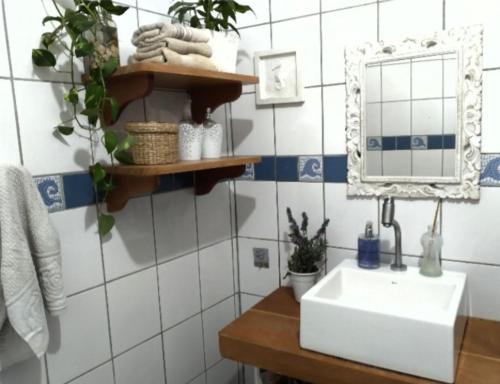 y baño con lavabo y espejo. en Quarto em casa compartilhada, en Florianópolis