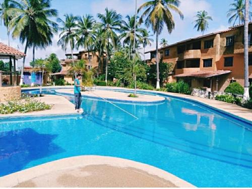 a person is standing next to a large swimming pool at Villa Vacacionales Los Cayos Con Playa Privada in Boca de Aroa