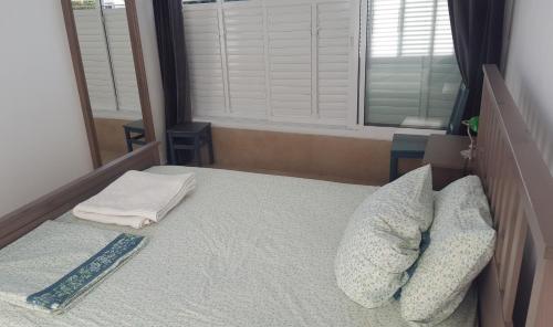 a bedroom with a bed with pillows and a window at Room near Sheba Medical Center, and Bar Ilan, and TLV Airport in Qiryat Ono