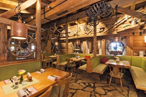 um restaurante com mesas e cadeiras e paredes de madeira em Alpenresidenz Buchenhöhe em Berchtesgaden