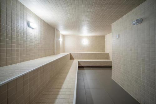 a large bathroom with a tub and tiled walls at Golden Gramado Resort in Gramado