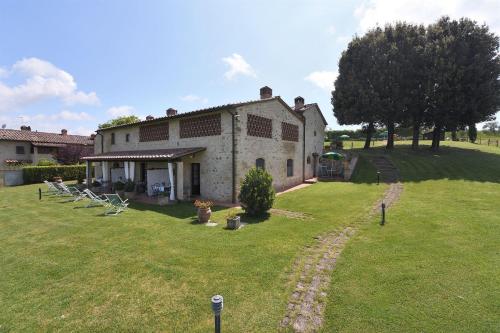 a large stone house with a yard with chairs at Fieno in SantʼAppiano