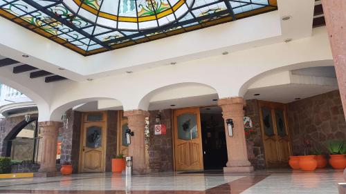 a lobby with wooden doors and a stained glass ceiling at Best Western Toluca in Toluca