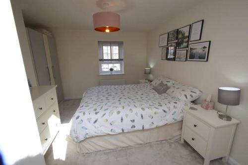 een slaapkamer met een wit bed en een raam bij The Coach House in Kirby Muxloe
