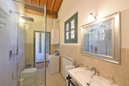 a bathroom with a sink and a glass shower at Il Sole in Gaiole in Chianti